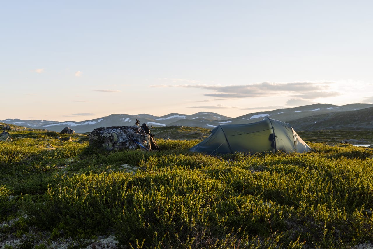 Telt på Hardangervidda i solnedgang, med rolige fjell i bakgrunnen.