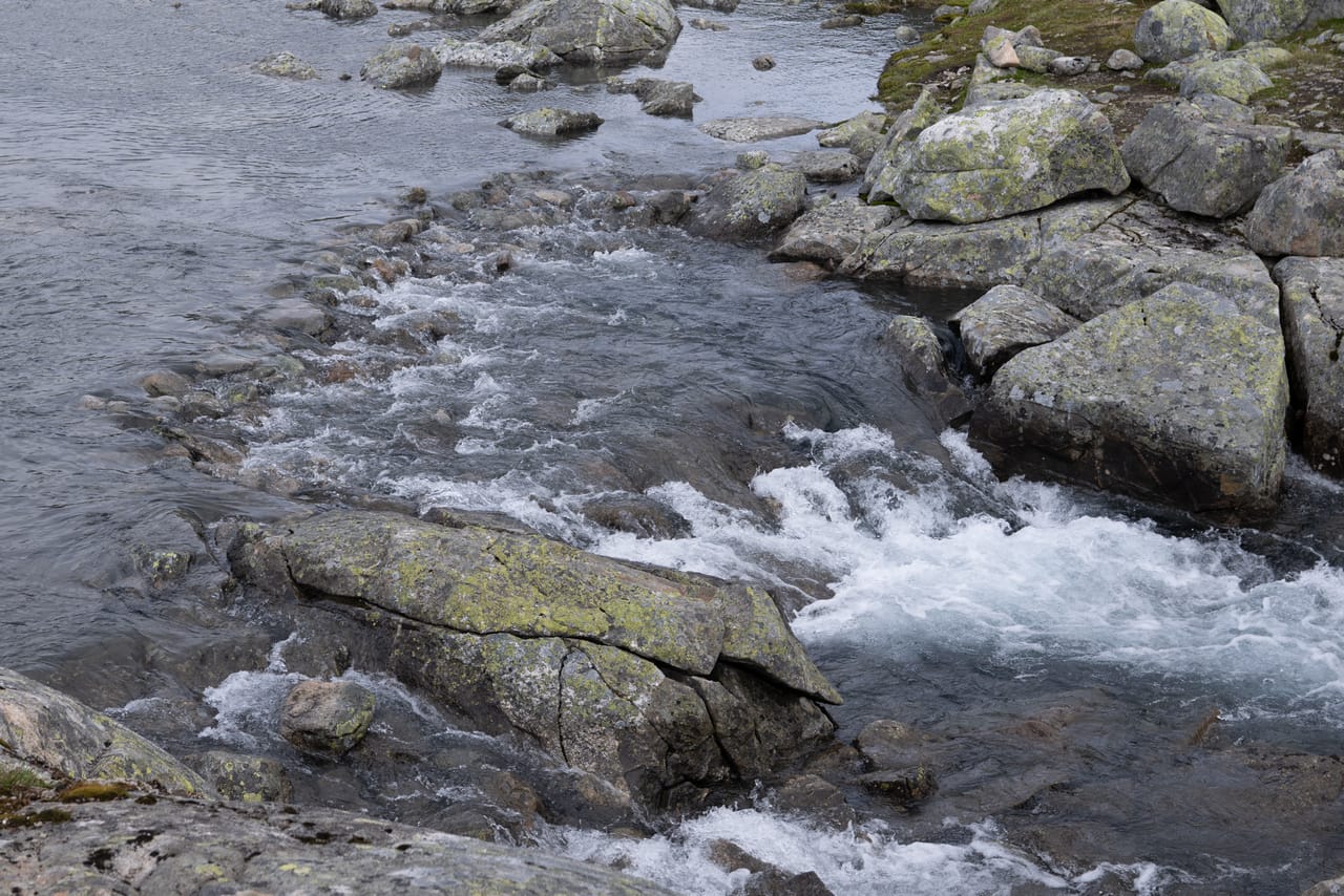Fossende vann mellom svaberg, sett ovenfra.