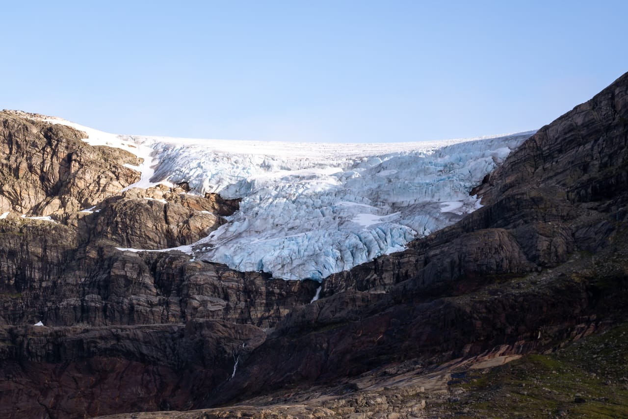 Nærbilde av Hardangerjøkulen, med blå brefall og bart fjell rundt.